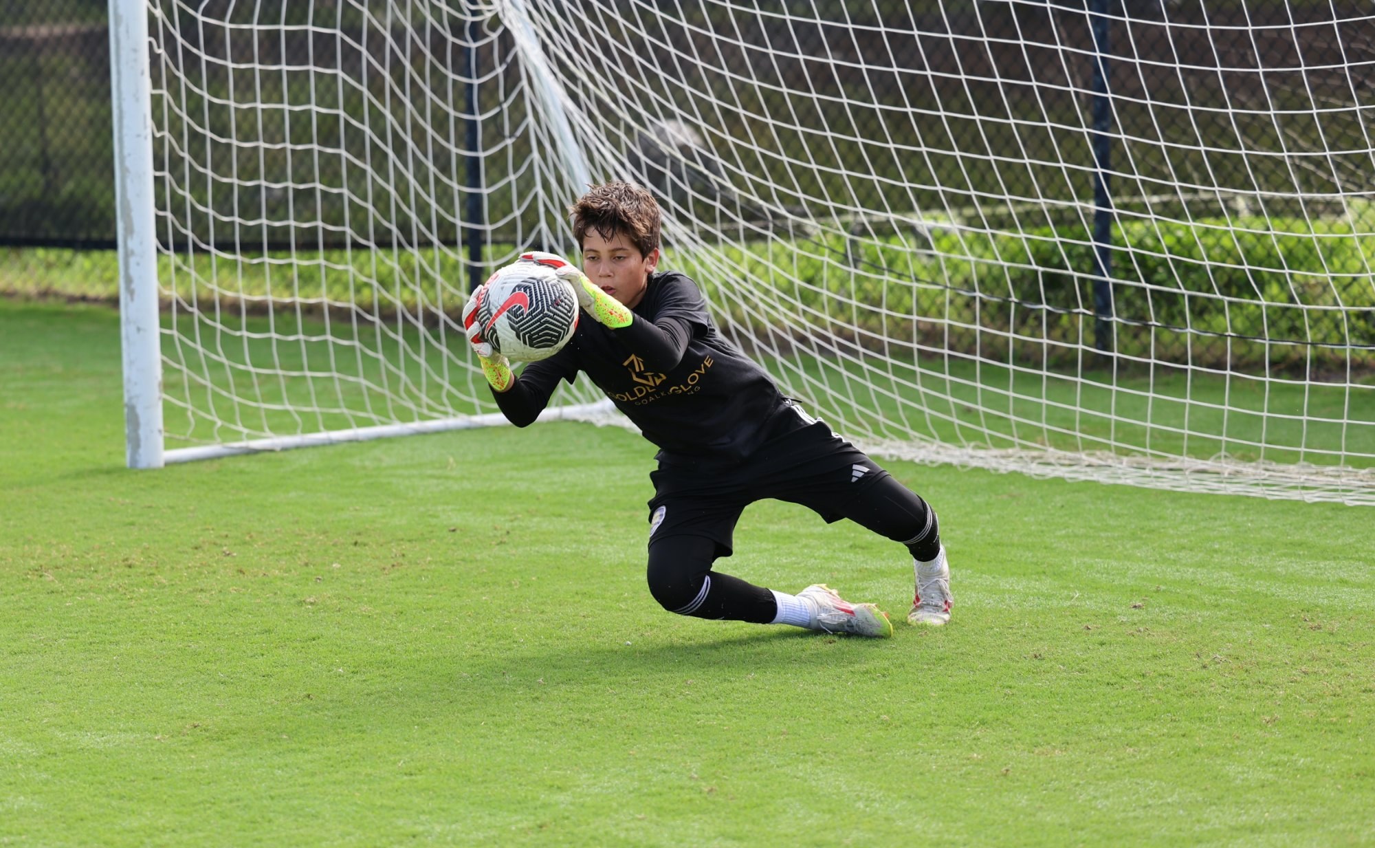 Young goalkeeper making a diving catch in training